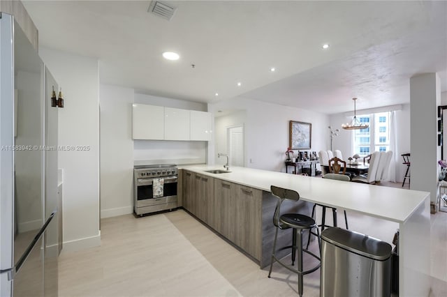 701 Brickell Key Blvd Unit Lph-06, Miami, FL 33131 - kitchen with stainless steel stove, modern cabinets, a peninsula, a sink, and light countertops