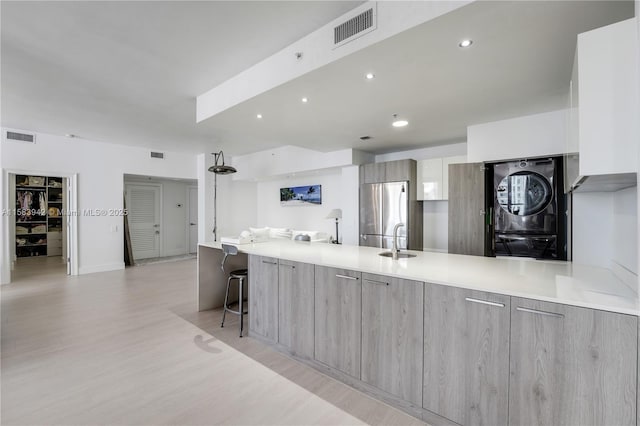 kitchen featuring visible vents, washer / dryer, modern cabinets, and freestanding refrigerator