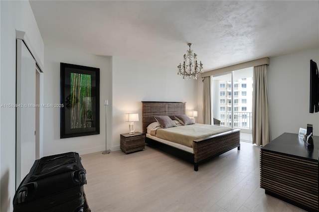 bedroom with a chandelier, a closet, baseboards, and wood finished floors