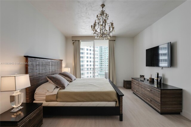 701 Brickell Key Blvd Unit Lph-06, Miami, FL 33131 - bedroom featuring a chandelier, light wood-style flooring, and baseboards