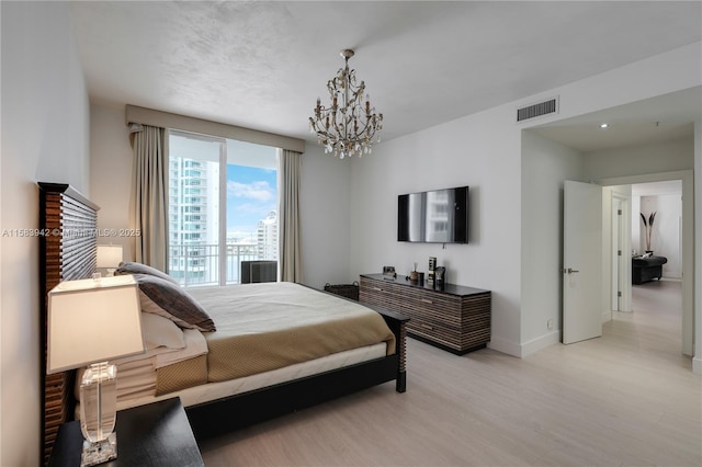 bedroom with a notable chandelier, baseboards, visible vents, and light wood finished floors