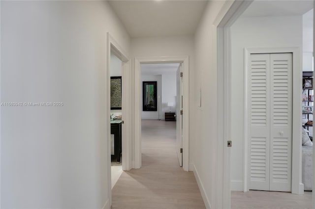 hallway with baseboards and light wood-style flooring