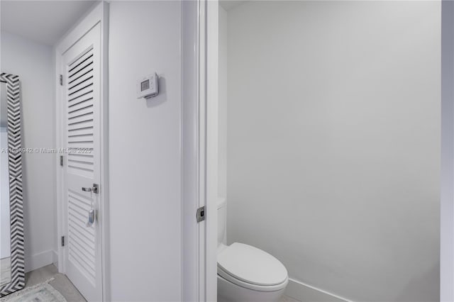 bathroom with baseboards and toilet