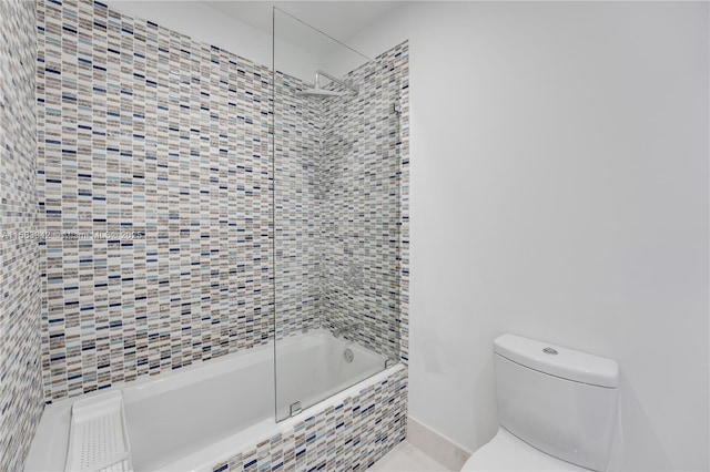 full bath with baseboards, toilet, and tiled shower / bath combo