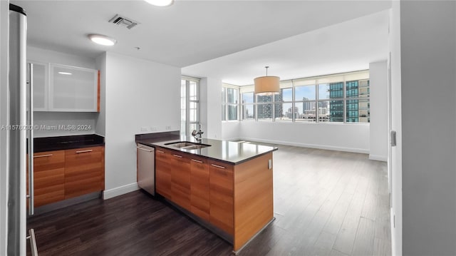 kitchen with stainless steel appliances, dark hardwood / wood-style floors, sink, and hanging light fixtures