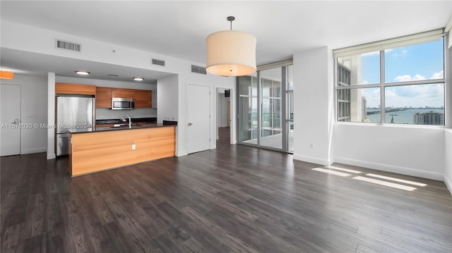 kitchen with sink, stainless steel appliances, dark wood-type flooring, and pendant lighting