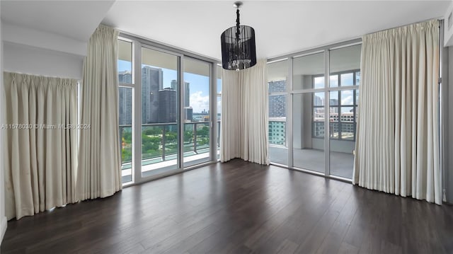 unfurnished room featuring dark hardwood / wood-style flooring and a wall of windows