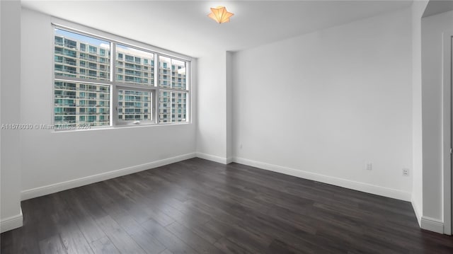 unfurnished room with dark hardwood / wood-style floors