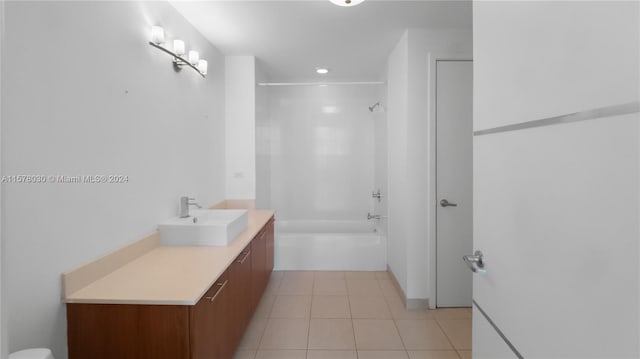 bathroom featuring vanity, tiled shower / bath combo, and tile floors