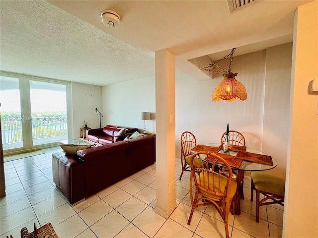 living room featuring a textured ceiling, french doors, and light tile flooring