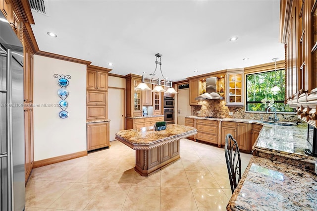 kitchen featuring crown molding, sink, wall chimney exhaust hood, decorative light fixtures, and a kitchen island