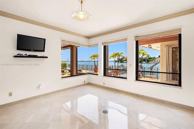 tiled spare room featuring a water view, a wealth of natural light, and ornamental molding