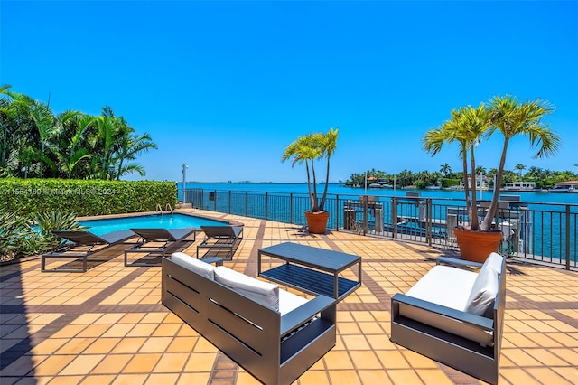 view of pool with an outdoor living space, a water view, and a patio