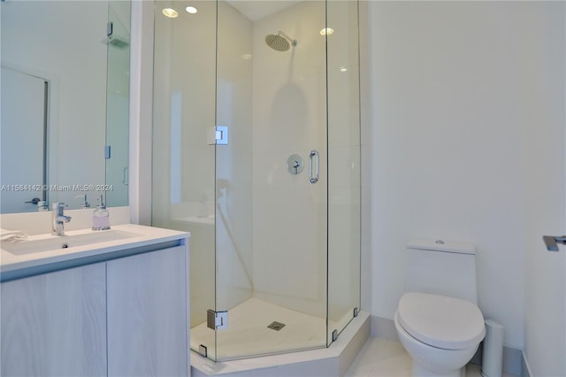 bathroom featuring an enclosed shower, toilet, and large vanity