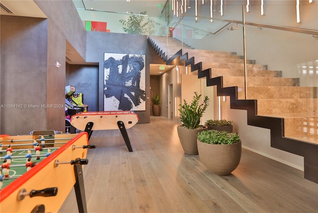 interior space with a towering ceiling and hardwood / wood-style flooring