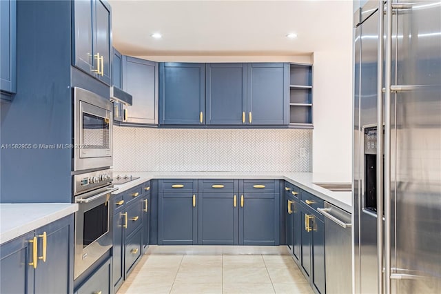 kitchen featuring stainless steel appliances, blue cabinetry, and backsplash