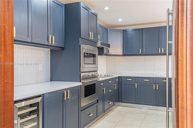 kitchen featuring appliances with stainless steel finishes, backsplash, blue cabinetry, and beverage cooler