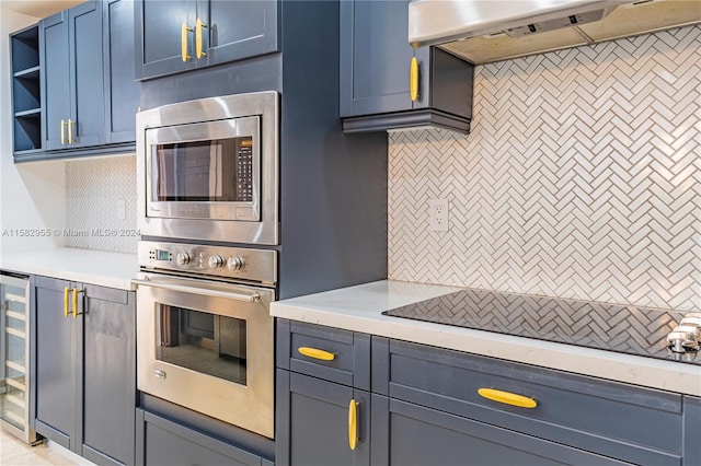 kitchen featuring stainless steel appliances, blue cabinets, and tasteful backsplash