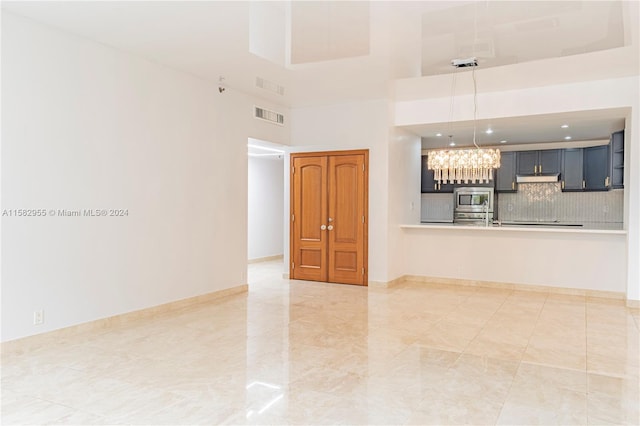 unfurnished living room with a high ceiling and light tile floors