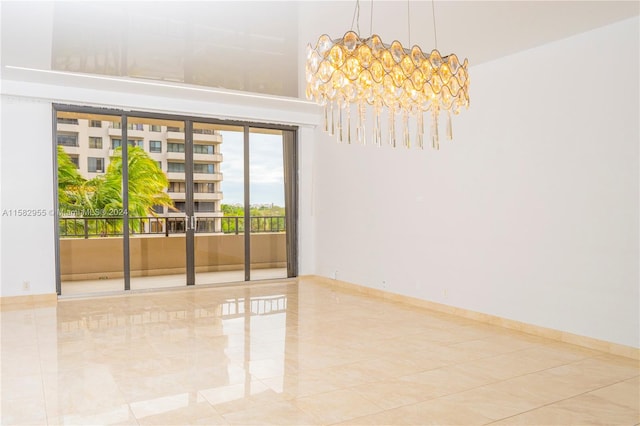 empty room with tile flooring and a chandelier