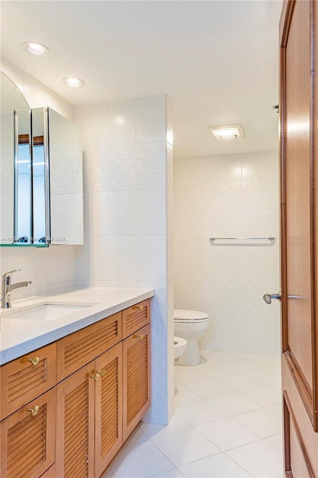 bathroom featuring tile walls, tile floors, a bidet, and toilet