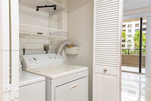 clothes washing area with separate washer and dryer, electric dryer hookup, and light tile floors