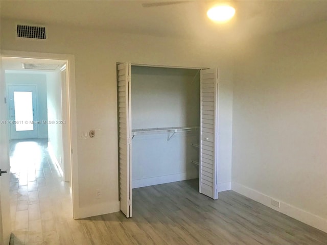 unfurnished bedroom with a closet and wood-type flooring