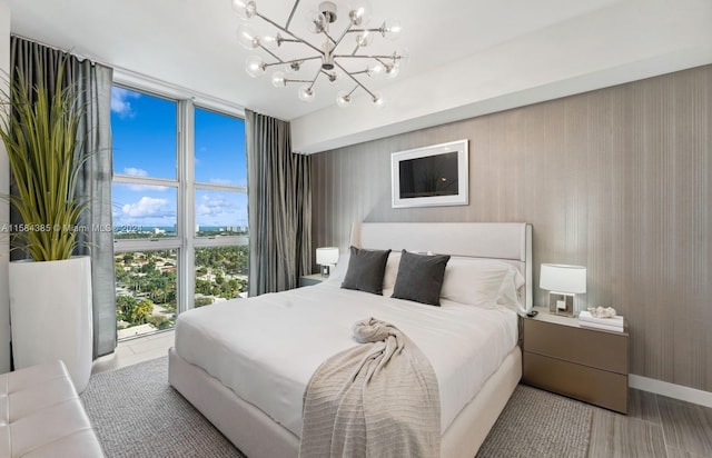 bedroom with floor to ceiling windows, a notable chandelier, and light hardwood / wood-style flooring