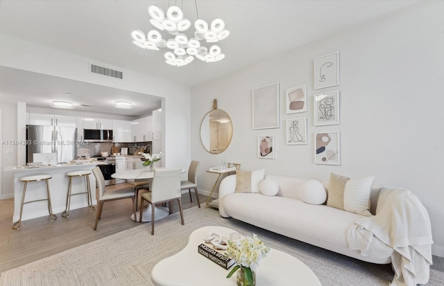 living room featuring a notable chandelier and light hardwood / wood-style floors