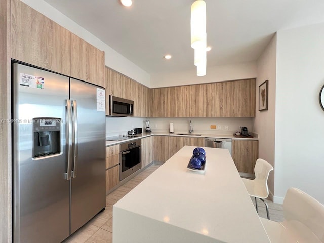 kitchen featuring appliances with stainless steel finishes, a kitchen island, light tile flooring, sink, and pendant lighting