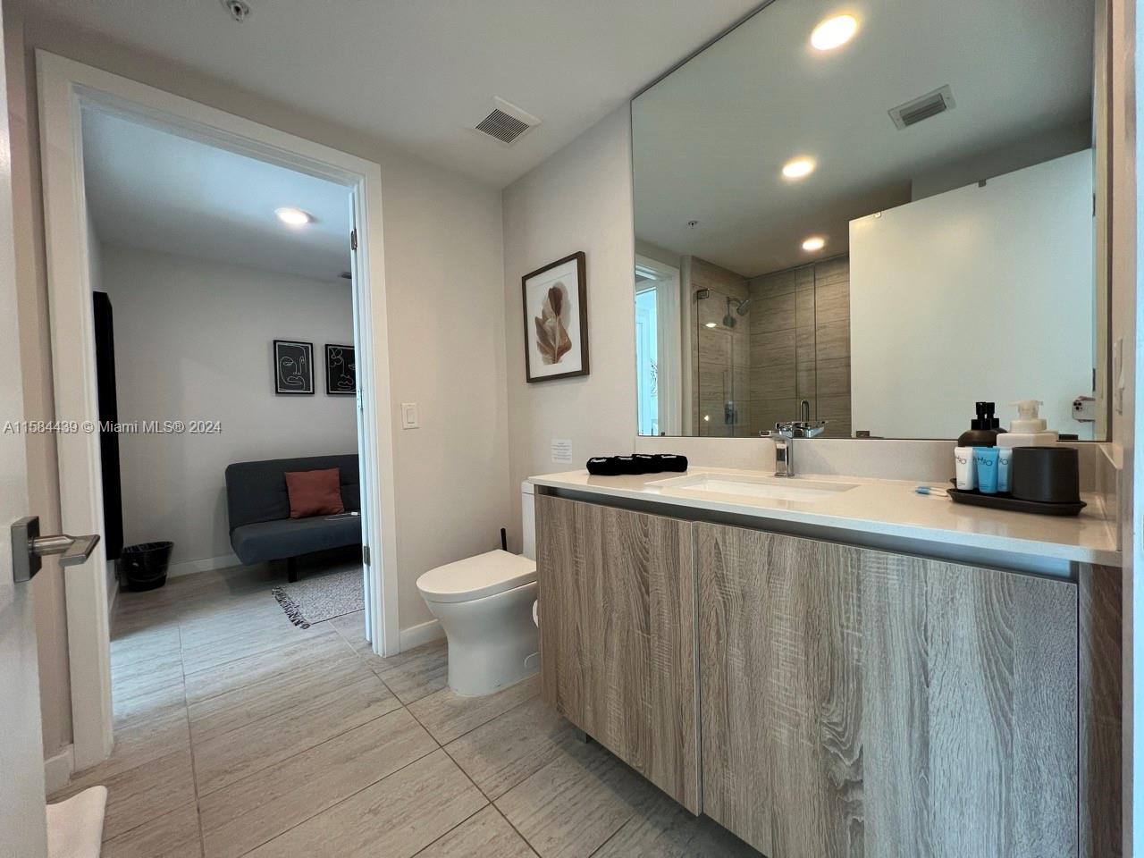 bathroom with oversized vanity, tile floors, and toilet