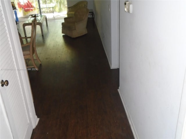 corridor with dark hardwood / wood-style flooring