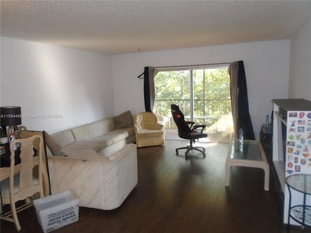 living room with dark hardwood / wood-style flooring and a textured ceiling