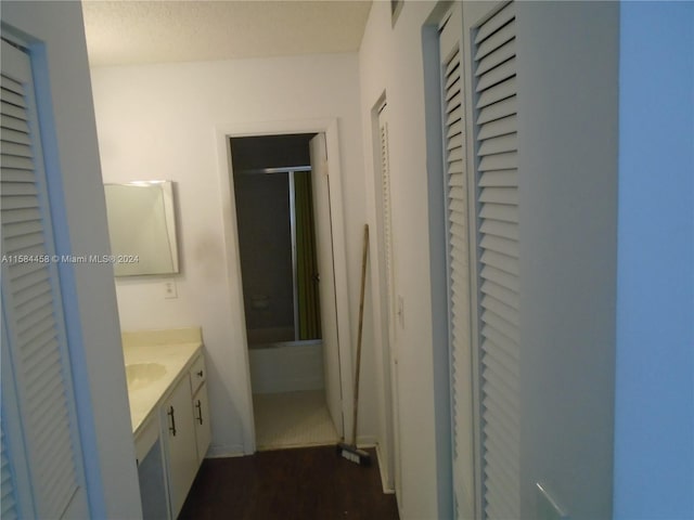 bathroom featuring vanity, a shower with shower door, wood-type flooring, and a textured ceiling