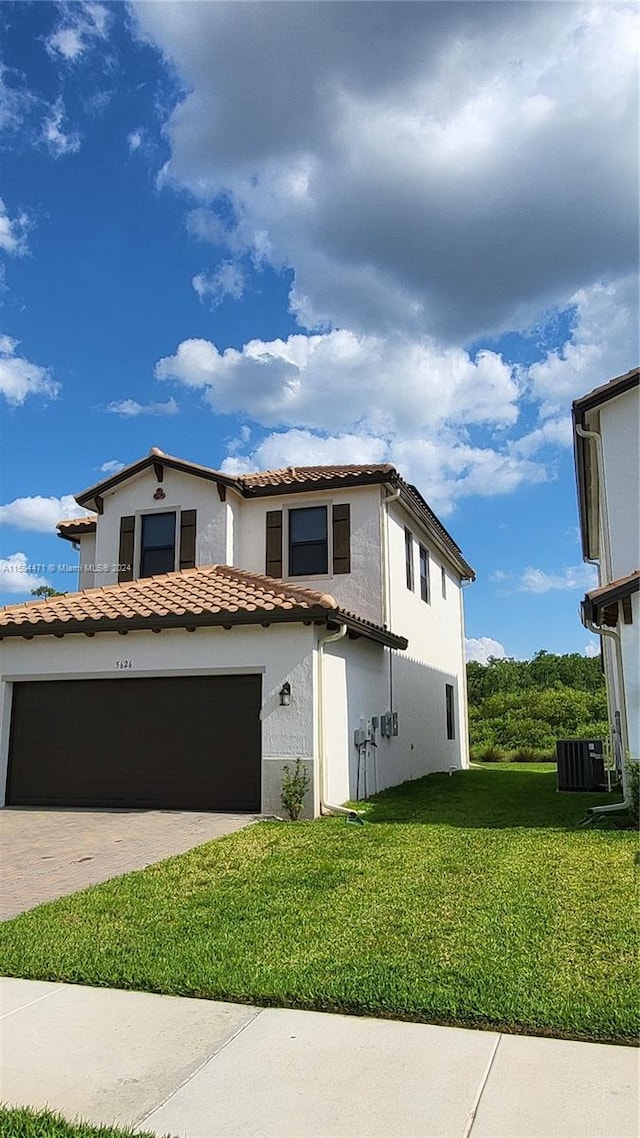 view of front of house with a front lawn, a garage, and cooling unit