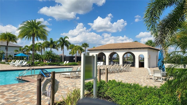 view of pool featuring an outbuilding and a patio