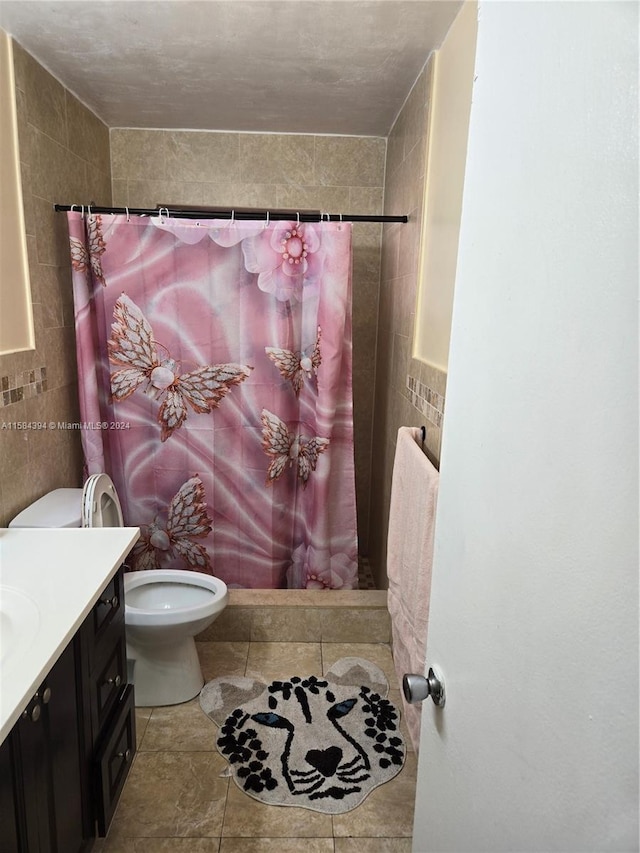 bathroom featuring vanity, a shower with shower curtain, tile patterned flooring, toilet, and tile walls