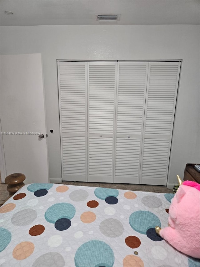 bedroom with light tile patterned floors and a closet