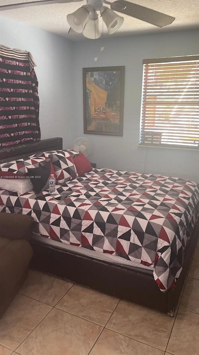 bedroom with ceiling fan and light tile patterned flooring