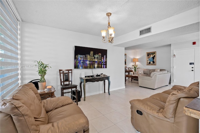 living room with light tile patterned floors, a chandelier, and a textured ceiling