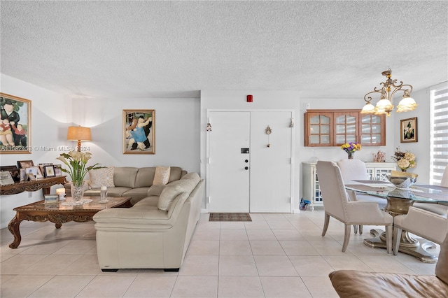 living room with a textured ceiling, an inviting chandelier, and light tile patterned floors