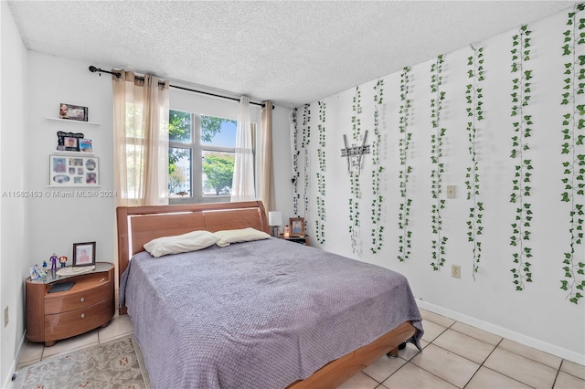 bedroom with a textured ceiling and light tile patterned flooring