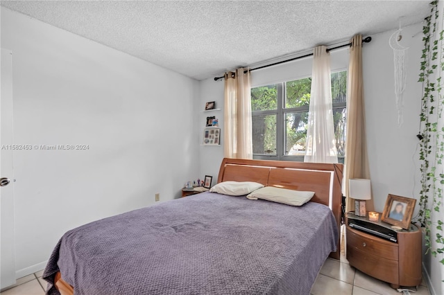 bedroom featuring a textured ceiling and light tile patterned floors