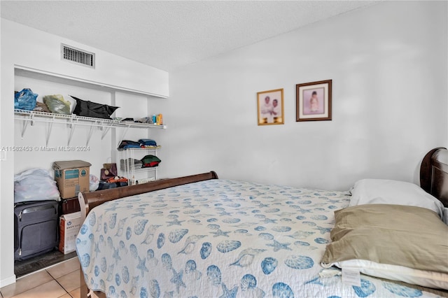 tiled bedroom featuring a textured ceiling