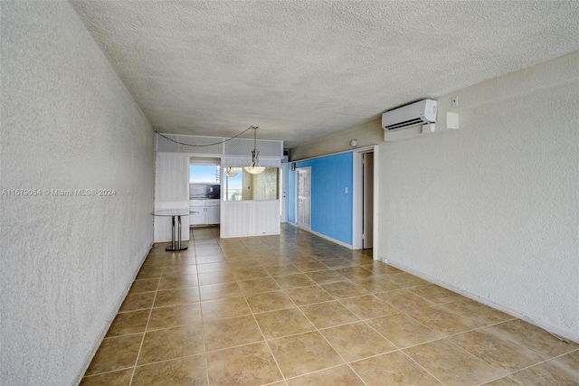 unfurnished living room featuring tile flooring, a textured ceiling, and a wall mounted air conditioner