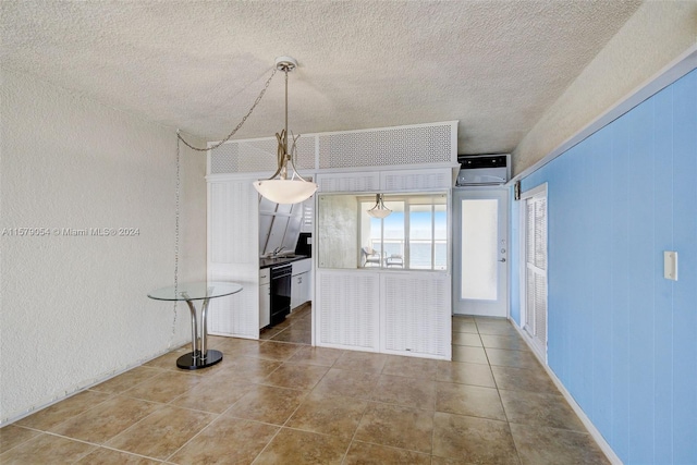 kitchen featuring hanging light fixtures, tile flooring, dishwasher, and a textured ceiling