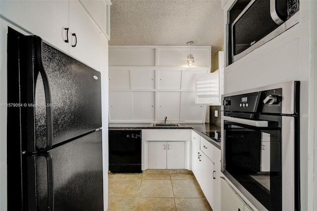 kitchen featuring pendant lighting, black appliances, light tile floors, sink, and white cabinetry