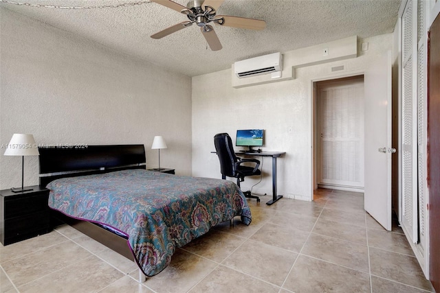 tiled bedroom with a textured ceiling, ceiling fan, and an AC wall unit