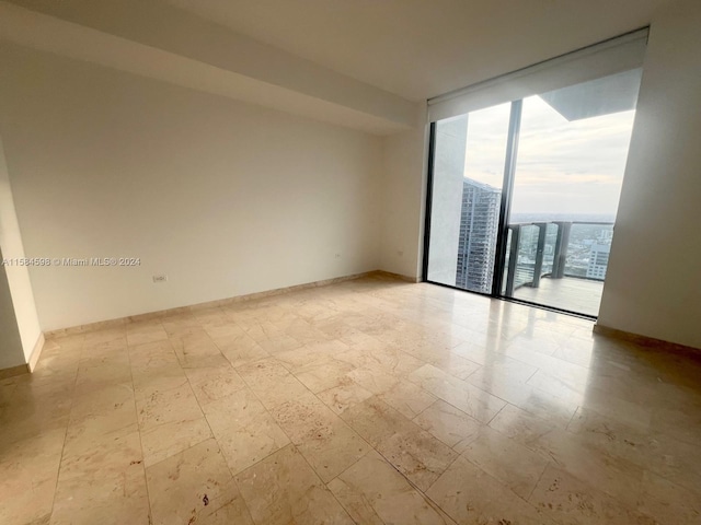 unfurnished room featuring light tile patterned floors and expansive windows