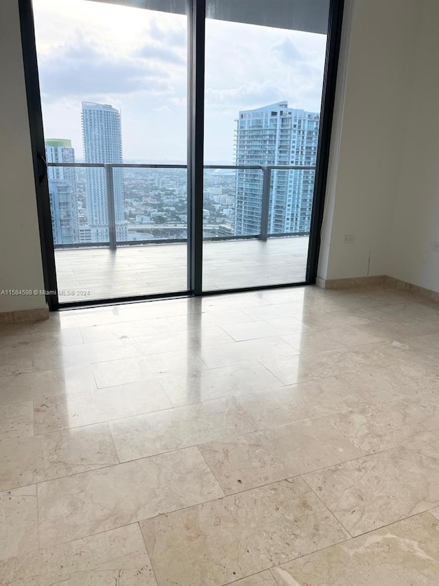 tiled empty room with floor to ceiling windows